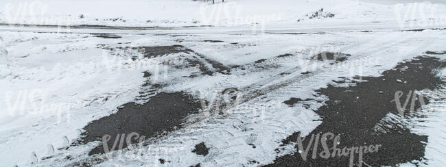 snowy tarmac with tyre tracks