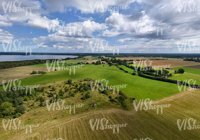 bird eye view of a landscape with fields by the sea