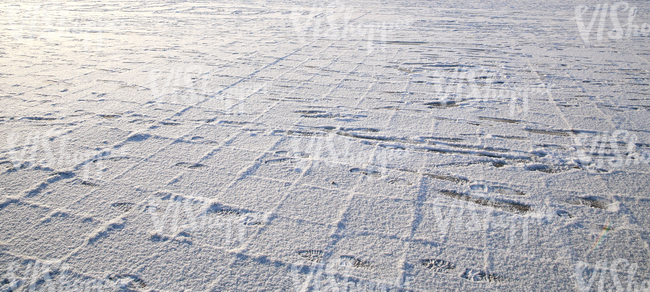 snow-covered pavement with footprints