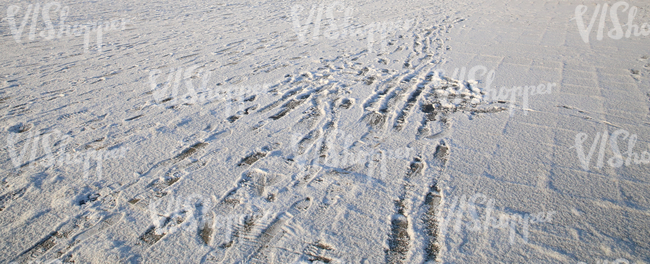 snow-covered pavement with footprints