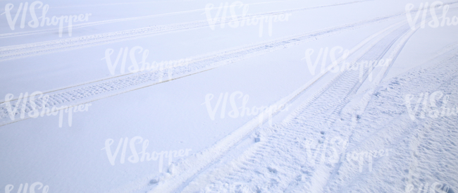 field of snow with snowmobile tracks