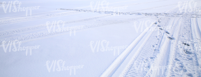field of snow with snowmobile tracks
