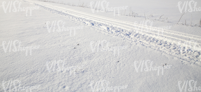 snow-covered ground with snowmobile tracks