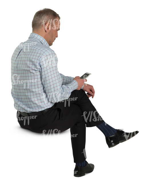 man sitting and looking at his phone