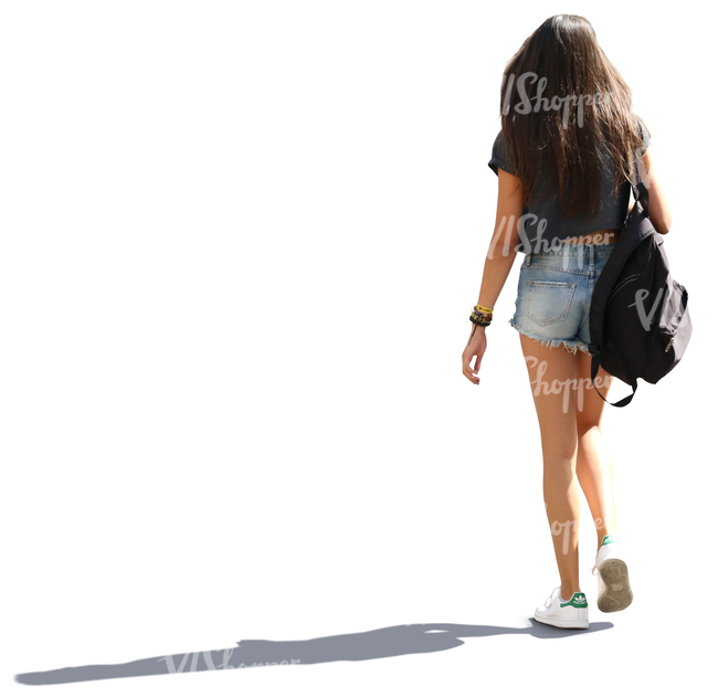 backlit young woman with long hair walking down the street