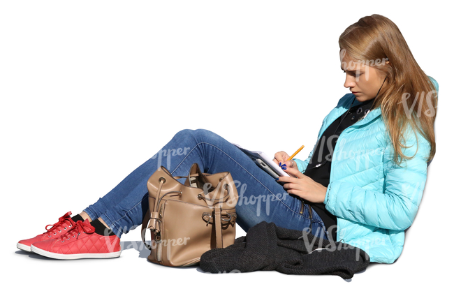 woman sitting on the ground and writing in her notebook