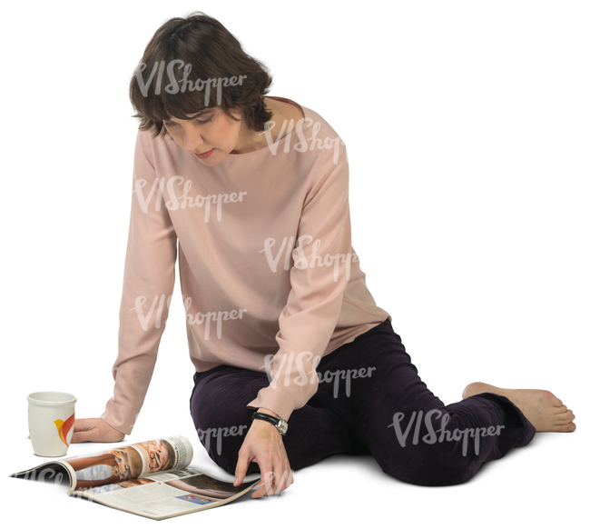 woman sitting on the floor and looking at a magazine