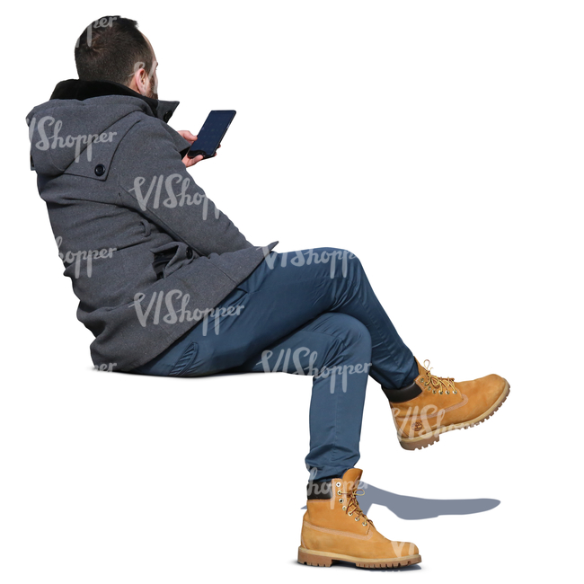 man in a grey autumn coat sitting and looking at his phone