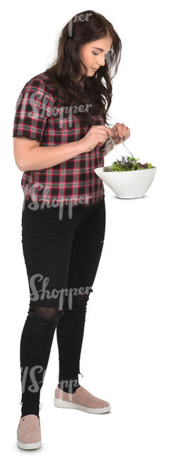 young woman standing in a kitchen and mixing salad