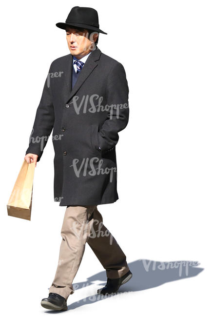 asian man in a black overcoat and hat walking in the sunlight