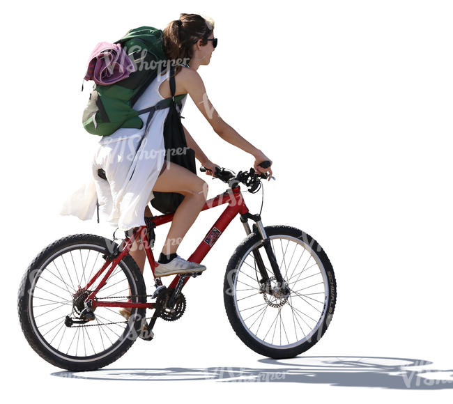 backlit woman with a backpack riding a bike