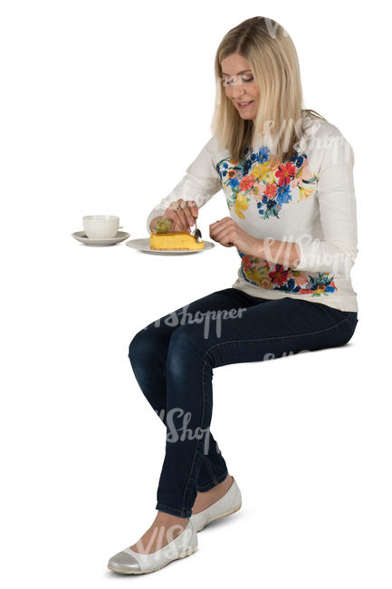 woman sitting in a cafe and eating cake