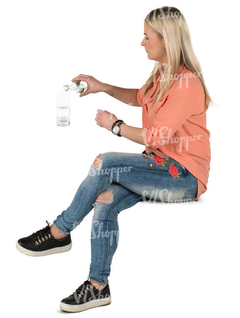 woman sitting in a cafe and pouring herself some water