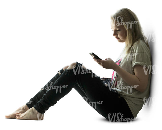 backlit woman sitting by the window and looking at her phone 