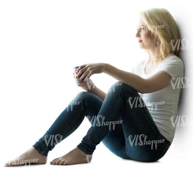 backlit woman sitting by the window and drinking coffee