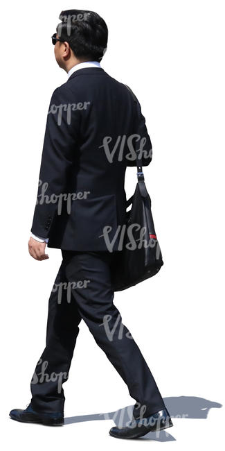 asian businessman in a black suit walking