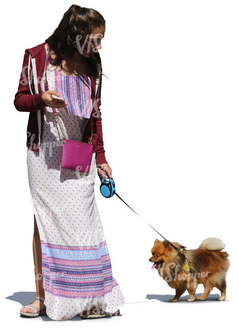 woman in a long summer dress walking a dog