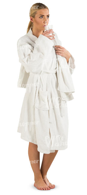 woman in a bathrobe standing and drinking water
