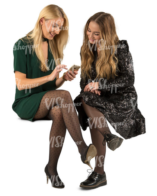 two women in party dresses sitting and talking