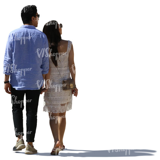 backlit asian couple walking hand in hand