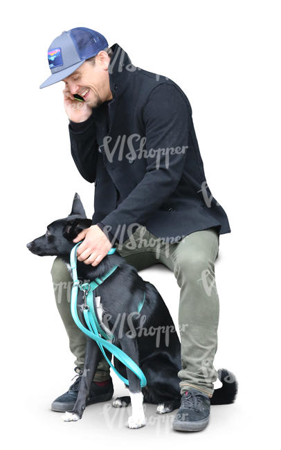 man sitting with his dog and talking on a phone