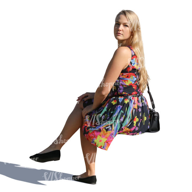 woman in a summer dress sitting and looking over her shoulder