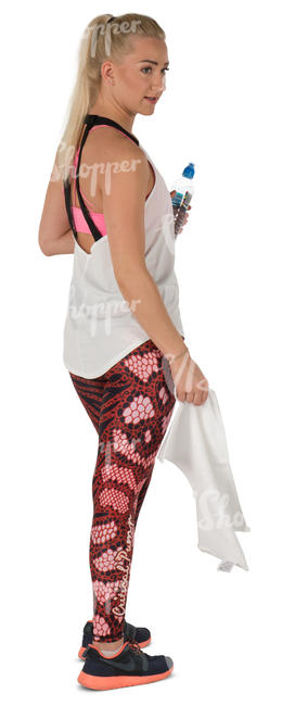 woman standing in a gym with a towel and water bottle