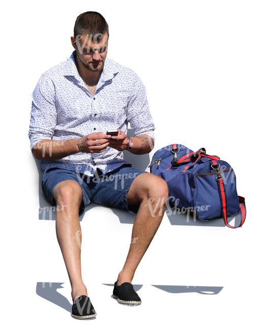 man with a gym bag sitting and texting
