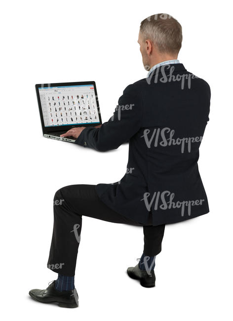 man in a suit sitting at his desk and working with a laptop