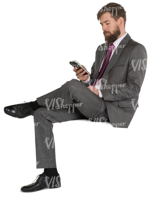 man in a fancy suit sitting and texting
