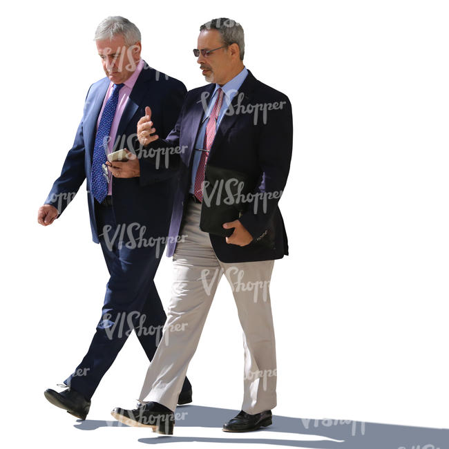 two backlit businessmen walking and talking