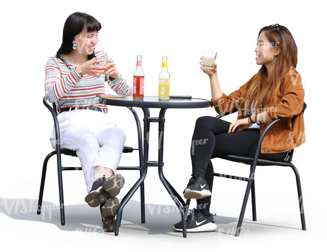 two women sitting and talking in a street cafe