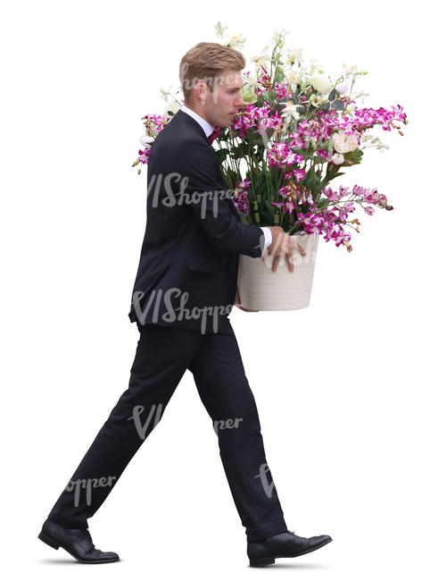 man in a black suit carrying a pot of flowers