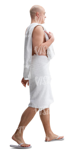 man in a towel and fliplops walking