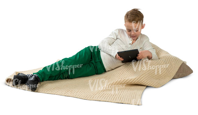 boy lying on a cushion and looking at a tablet