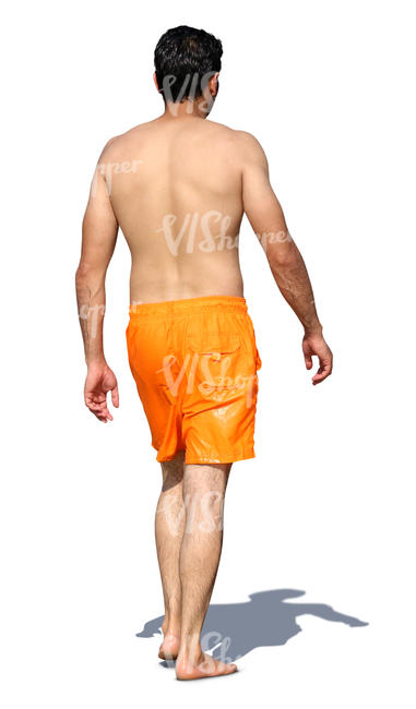 man in orange shorts walking barefoot on the beach