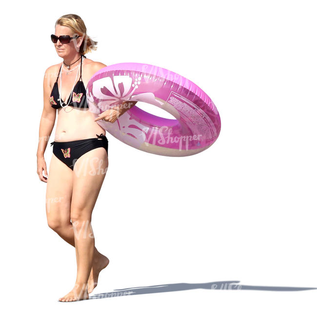 woman walking on the beach and carrying a floatie