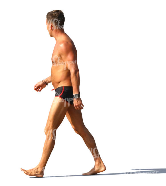 man in a swimsuit walking on the beach