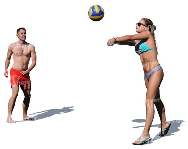 man and woman playing volleyball on the beach