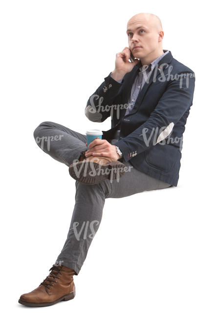 man sitting and talking on a phone while drinking coffee