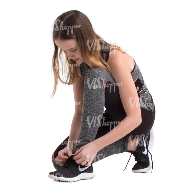 girl in sports outfit squatting and tying her shoes