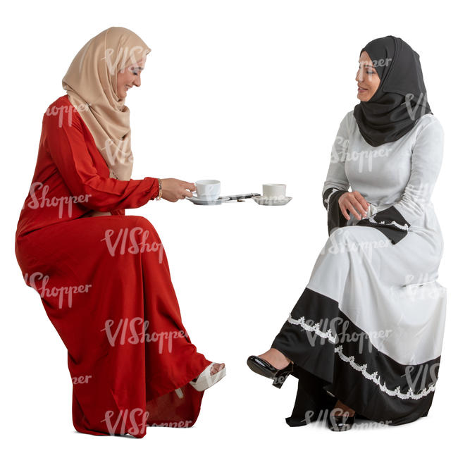 two muslim women sitting in a cafe and talking