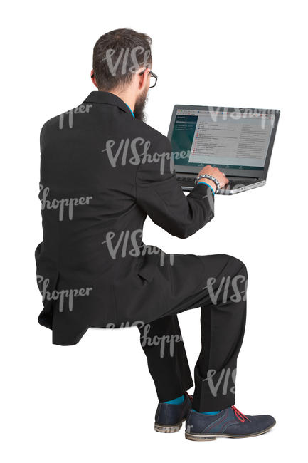 man in a suit sitting and working with laptop