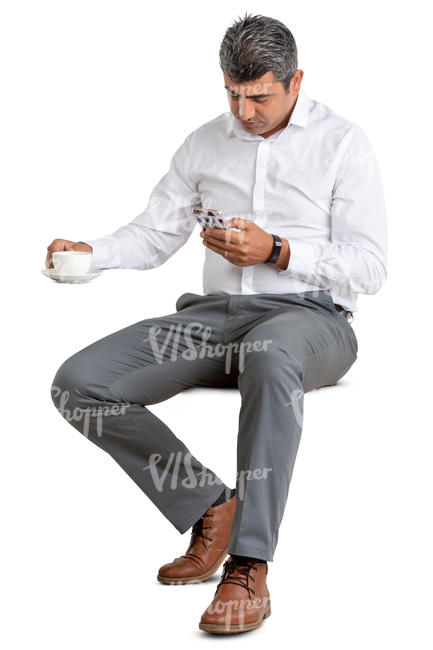 man in a suit sitting in a cafe and drinking coffee