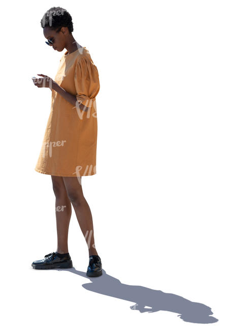 backlit african woman in a yellow dress standing