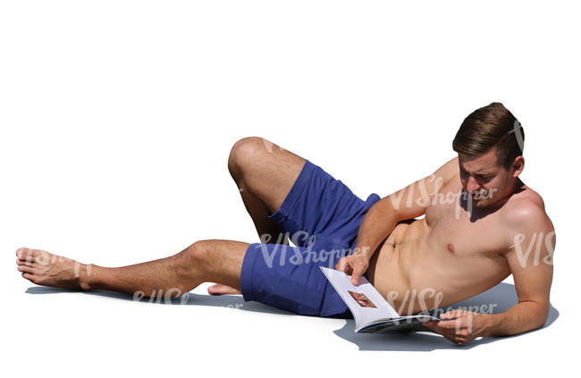 man lying on the beach and reading a magazine