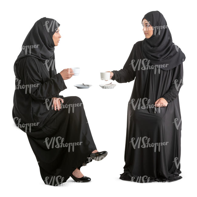 two arab women in abayas sitting in a cafe