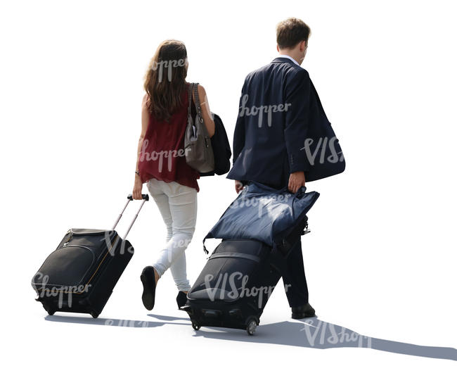backlit man and woman pulling big suitcases