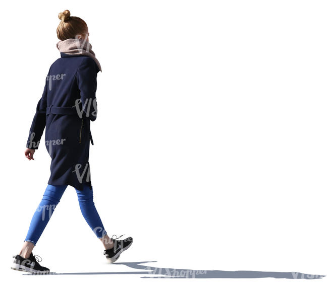 backlit young woman walking down the street