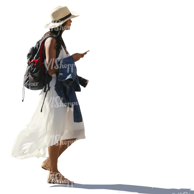 backlit woman in a white dress walking